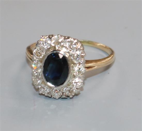 A yellow metal, sapphire and diamond set shaped oval cluster ring, size M.